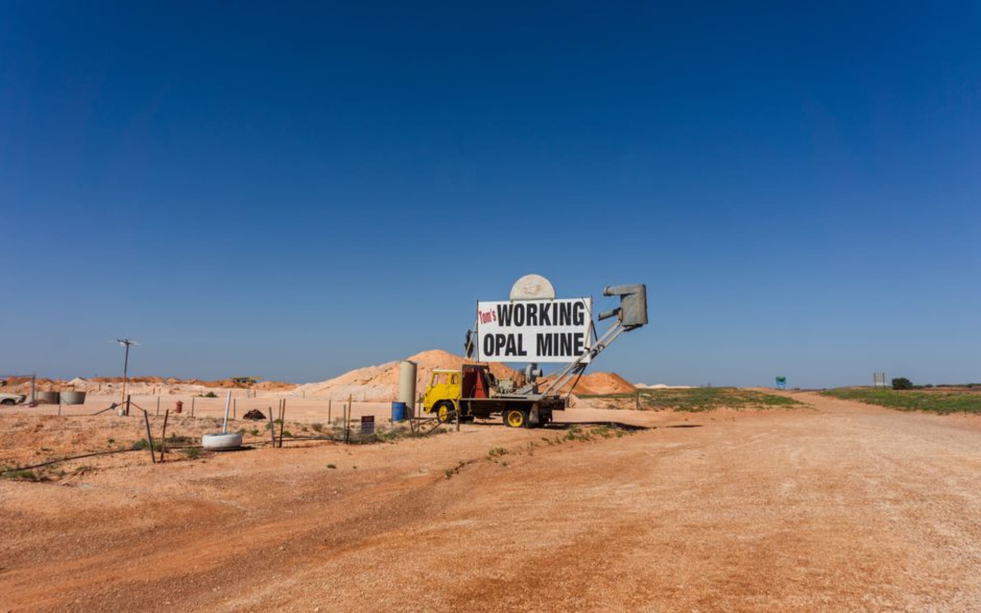 Mounds of pale mullock earth from opal mining shafts scattered across the red dirt landscape around Lightning Ridge