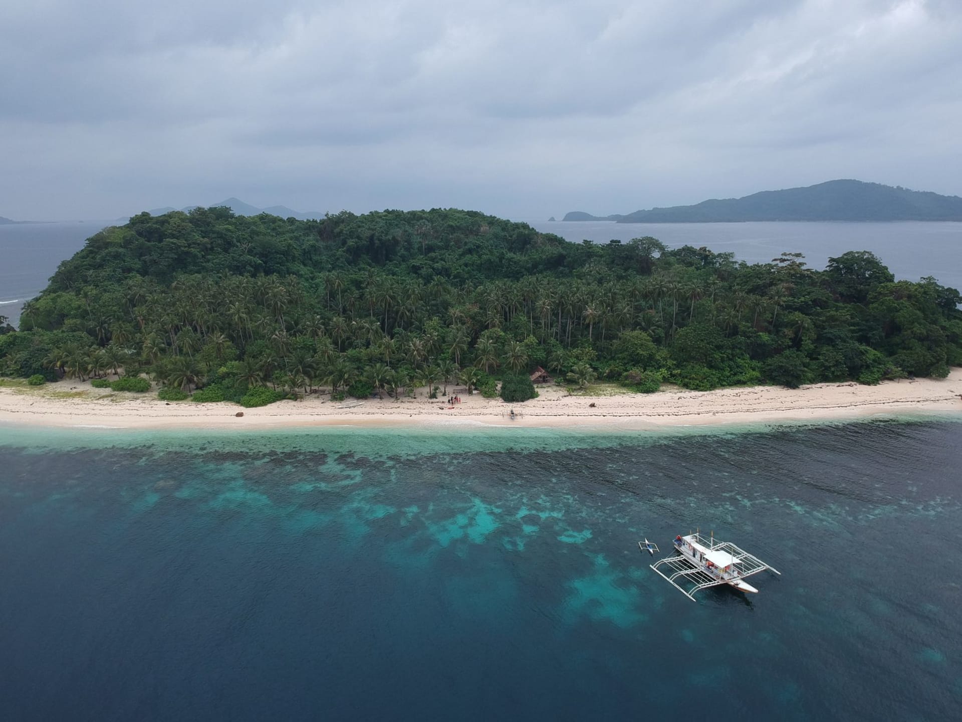 Clear turquoise water over white sand and limestone islets at Linapacan, northern Palawan, Philippines