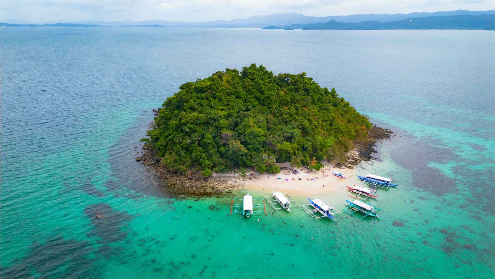Vast empty white sand beach at San Vicente Long Beach stretching to the horizon with dense jungle behind and turquoise water in front