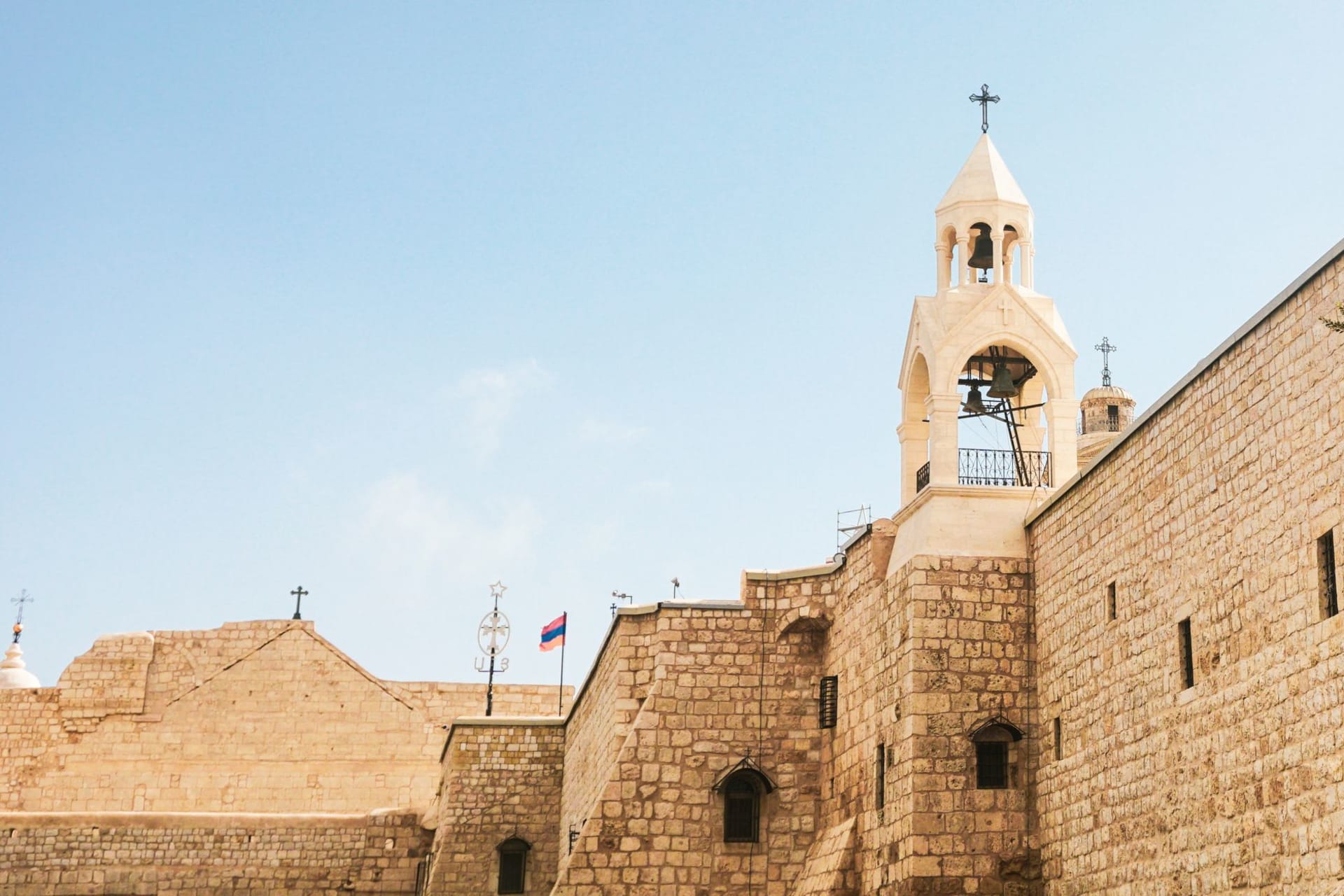 Stone facade of a historical church in Bethlehem under a clear blue sky