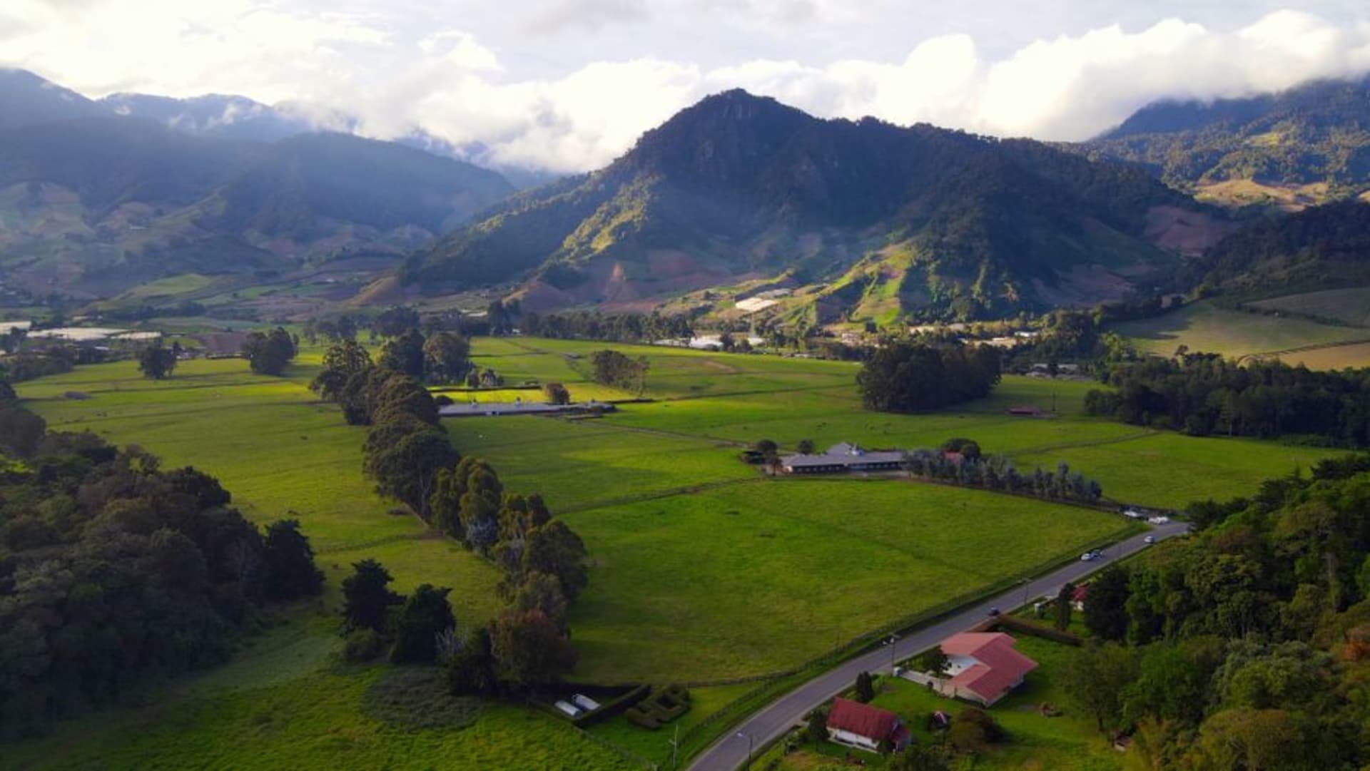 Terraced vegetable fields climbing the steep green slopes around Cerro Punta, with cloud forest and mountains rising behind.