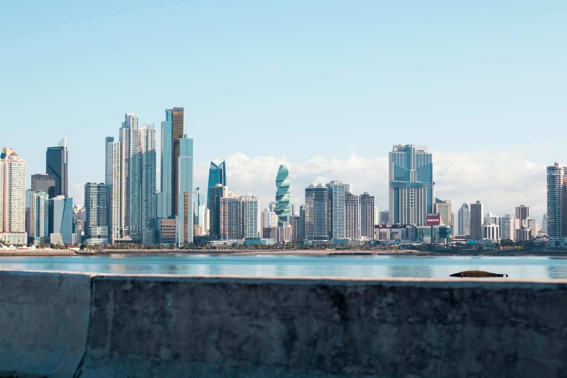 Casco Viejo's crumbling colonial facades in warm afternoon light, with Panama City's glass skyscrapers rising in the background across the bay