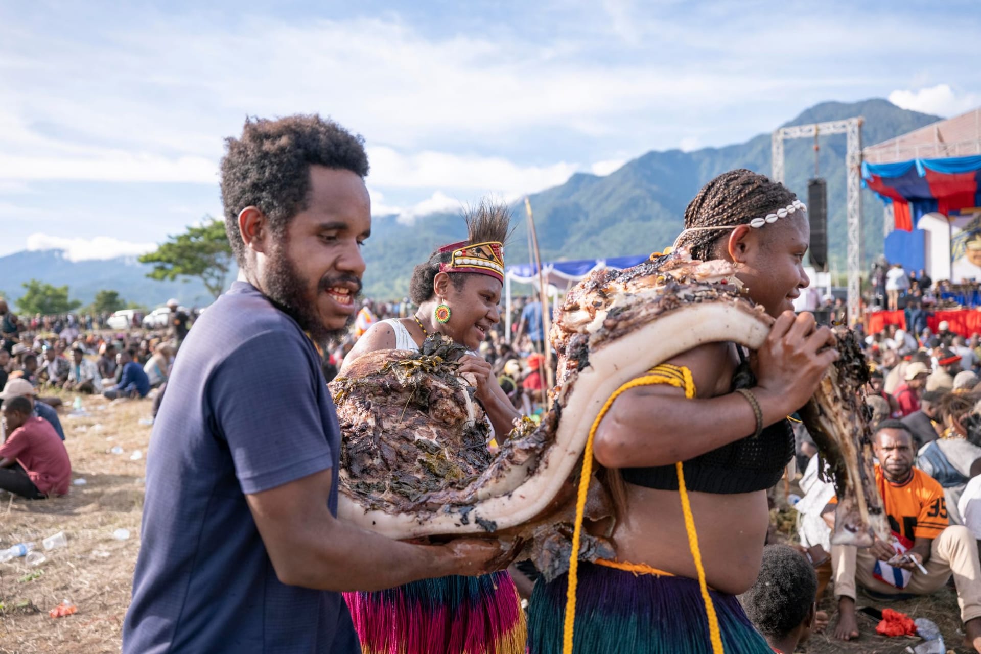 Mount Hagen's open-air market on a Saturday morning, a sea of colour from women's bilum bags and garden produce, with misty green highlands rising in the background