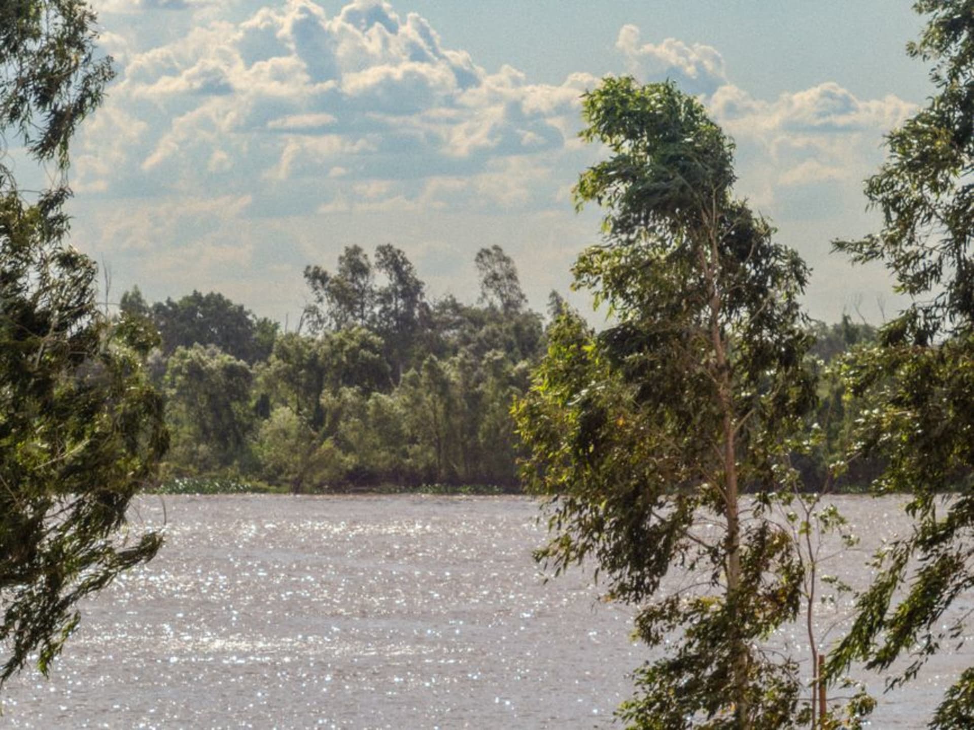 A weathered colonial mansion facade along the riverfront of Concepcion, its balcony overlooking the Paraguay River
