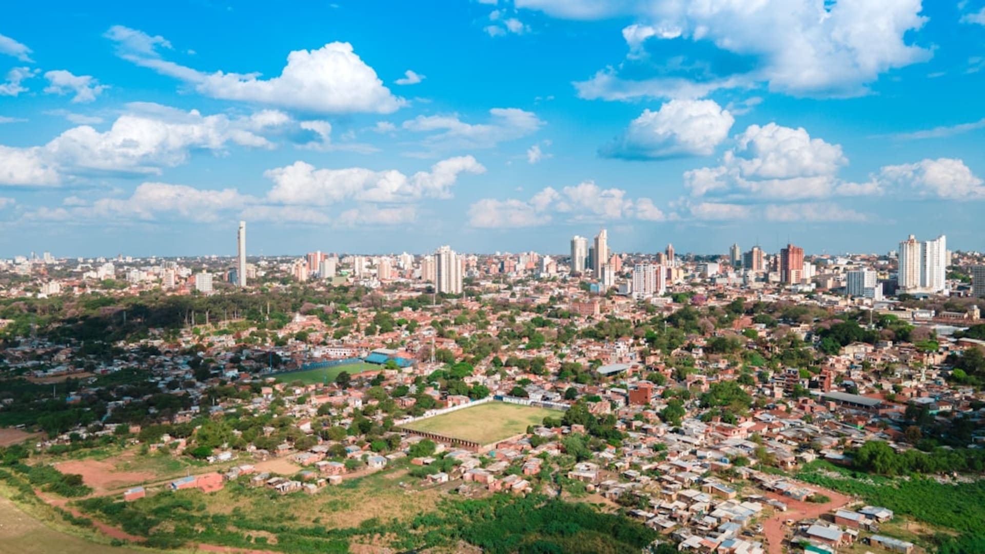 Wooden houses on stilts along the flood-prone riverside neighborhood of Pilar, the Paraguay River visible behind