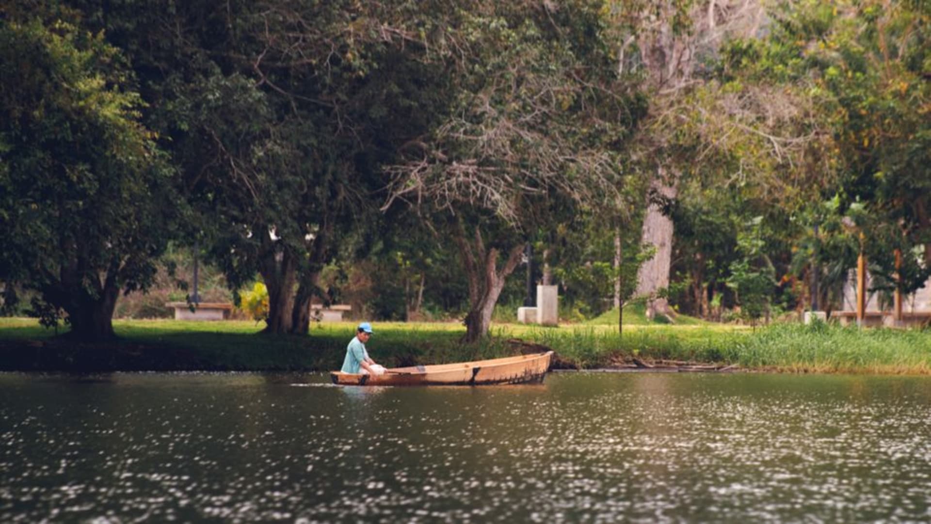 Una villa de madera centenaria con galería envolvente en San Bernardino, palmeras y el lago Ypacaraí visibles al fondo
