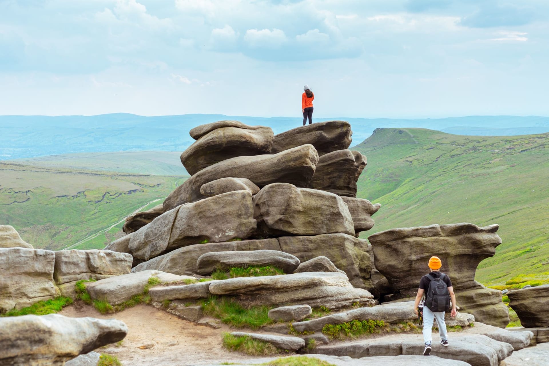 The dark peat groughs and weathered gritstone rocks of the Kinder Scout plateau under a brooding Peak District sky