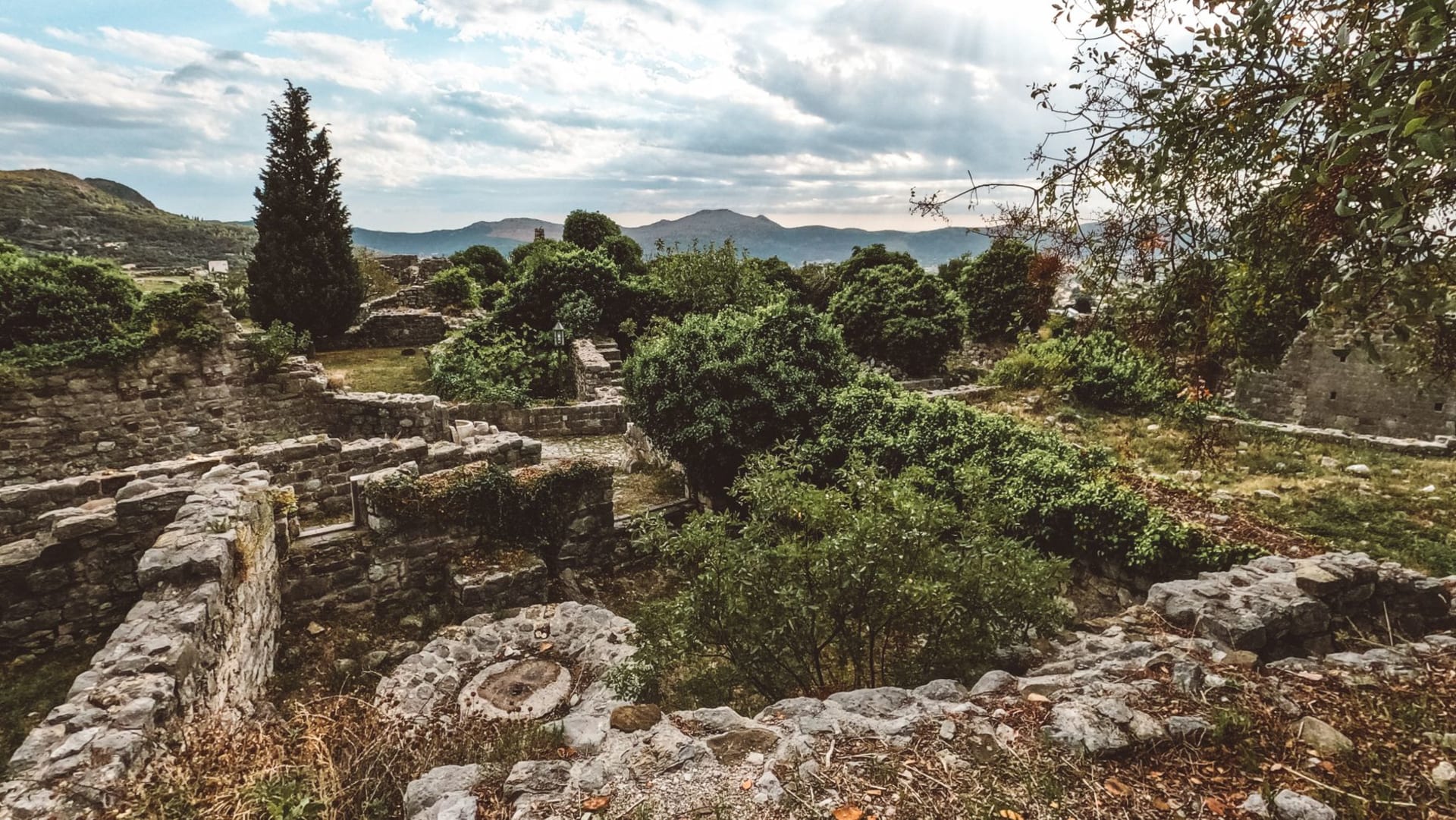The rooftops and domed churches of Byzantine Mystras cascading down a steep hillside with the Eurotas valley stretching below