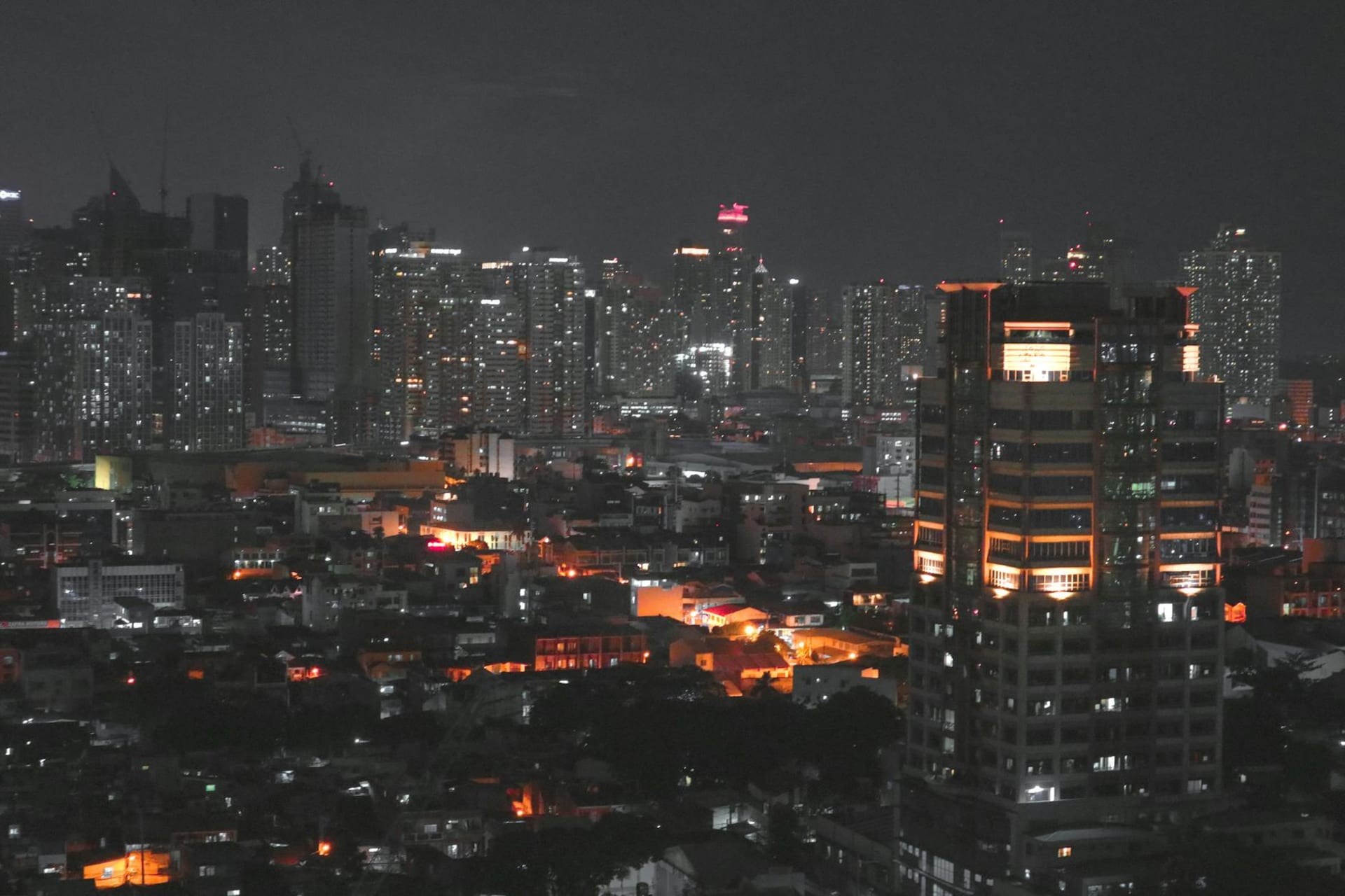 Manila skyline at dusk with city lights reflecting on the bay