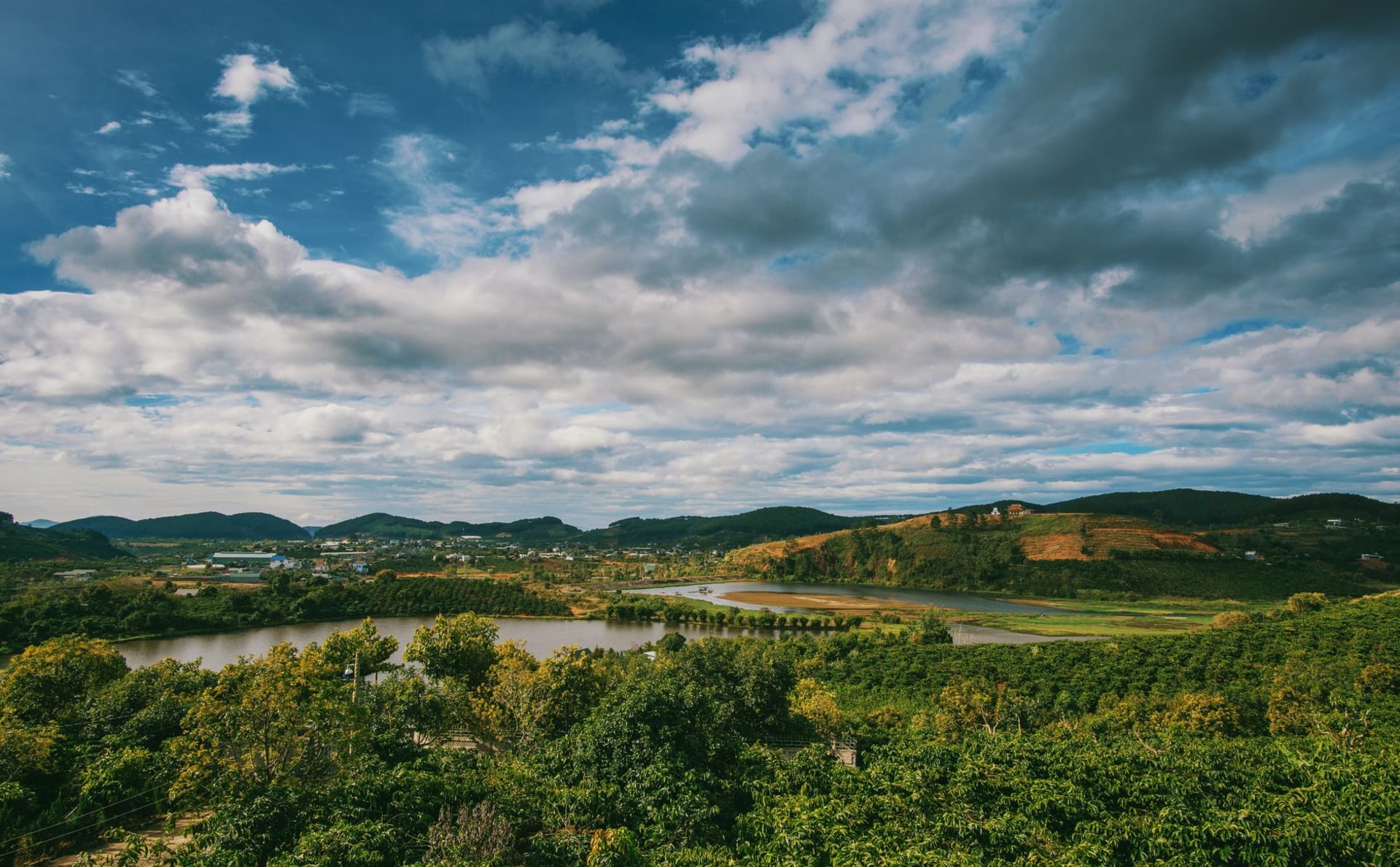 The Nam Ngum river winding through a green valley below the Xieng Khouang plateau, mountains rising on both sides