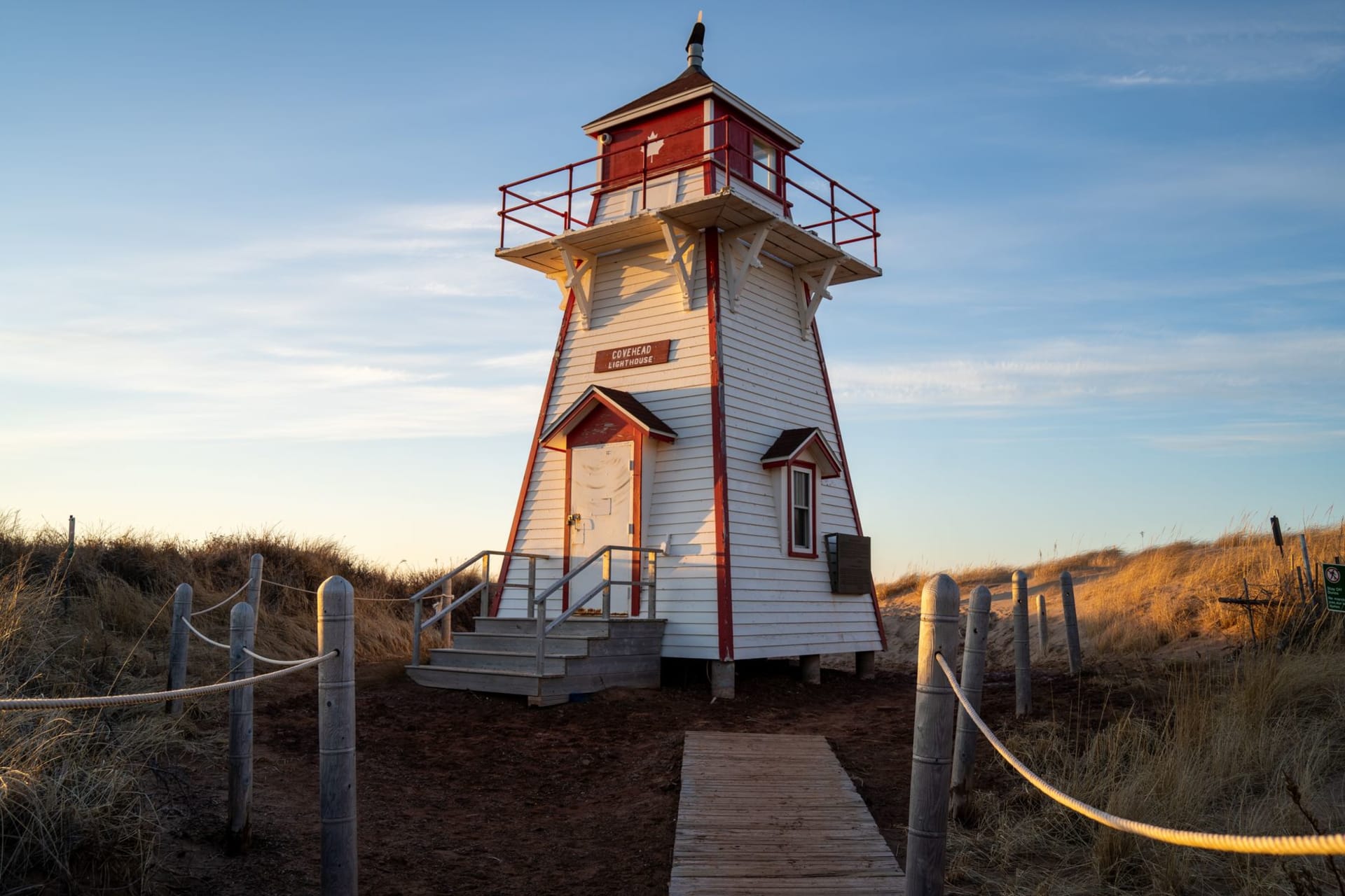 Spinnakers' Landing boardwalk in Summerside at golden hour, the harbour turning bronze and pewter behind it