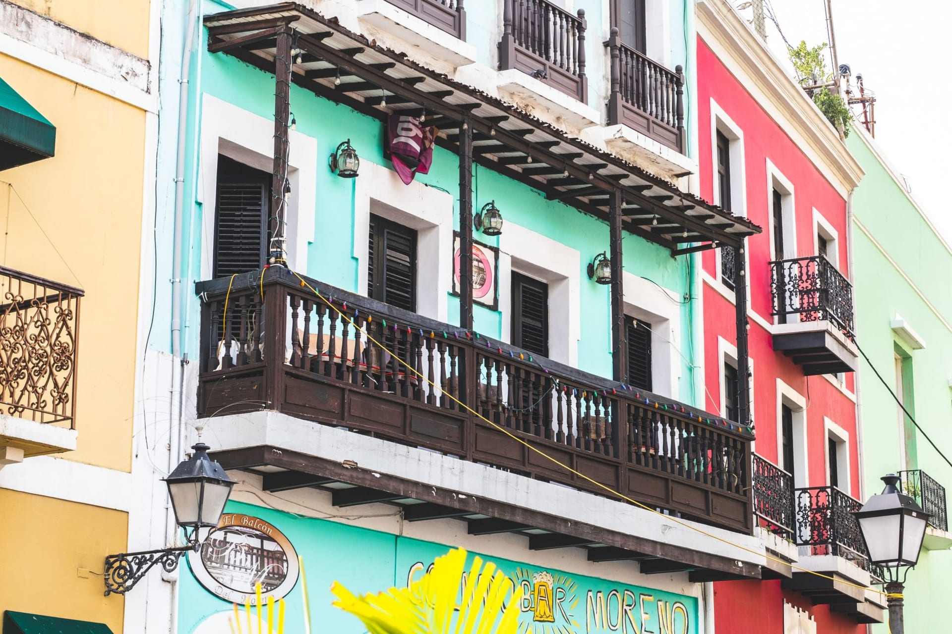 The iconic red and black striped Parque de Bombas firehouse on Plaza las Delicias in Ponce, fountain and cathedral visible behind it in afternoon light