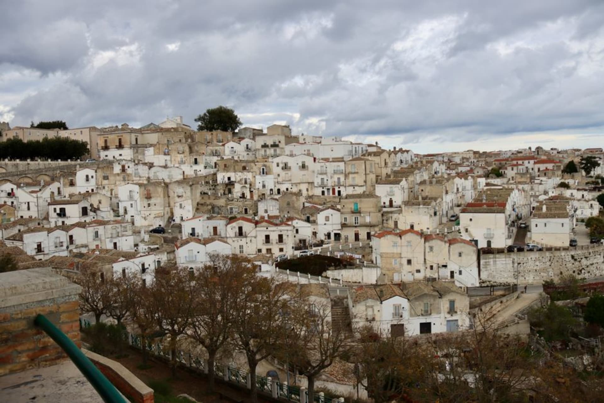 Las calles de piedra y el campanario del santuario de Monte Sant'Angelo sobre el macizo del Gargano, con vistas a la llanura de abajo