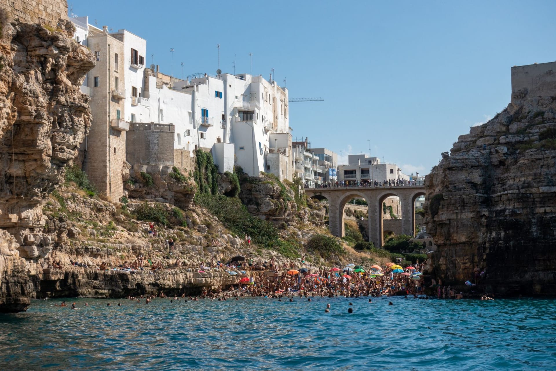 Polignano a Mare's white old town perched on dramatic limestone cliffs above turquoise Adriatic coves