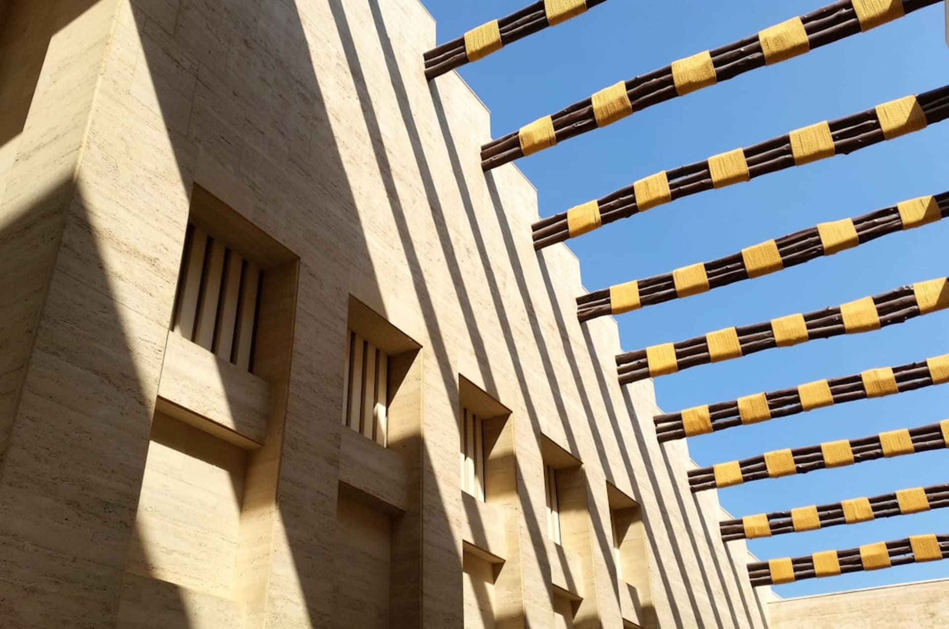 L'amphithéâtre à ciel ouvert de Katara Cultural Village au crépuscule, avec le littoral de Doha en arrière-plan