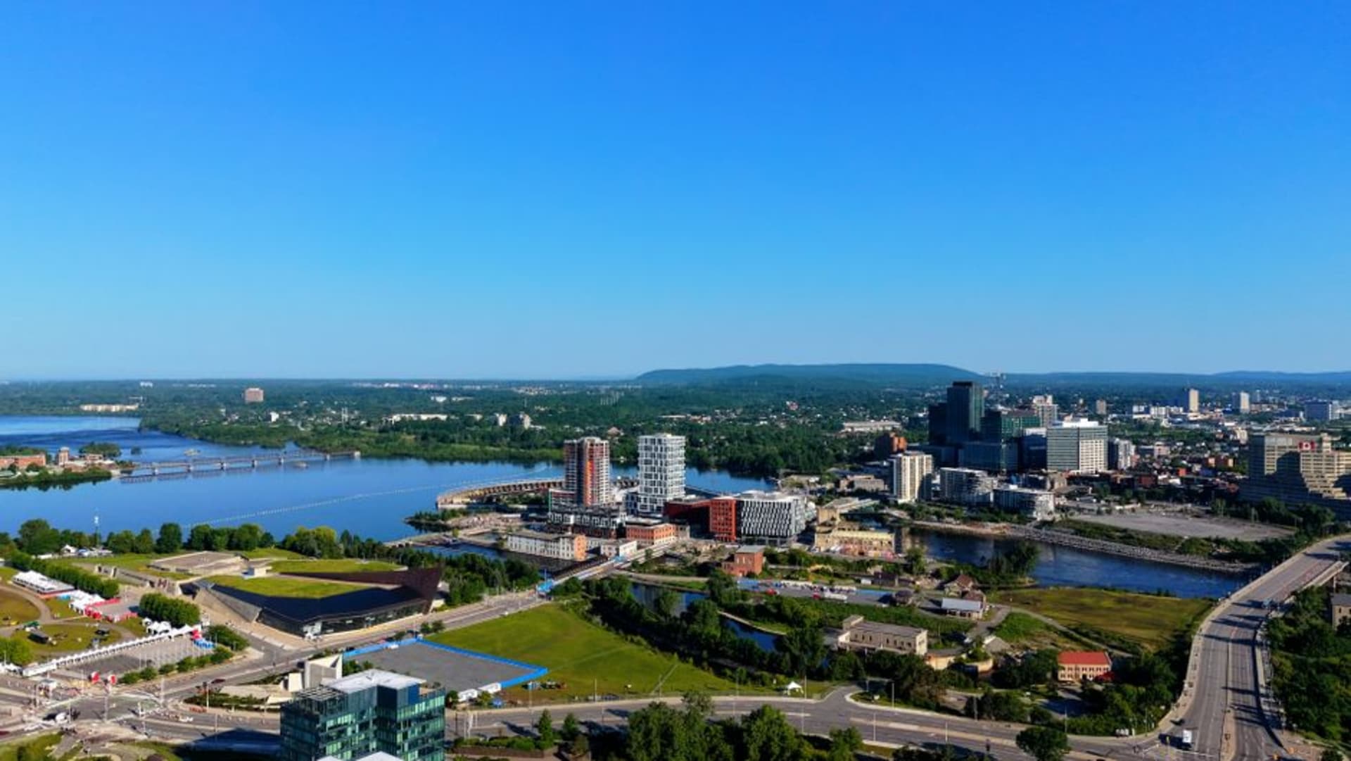 Le front de rivière des Outaouais à Gatineau au coucher du soleil, avec l'architecture courbe du Musée canadien de l'histoire visible sur la rive