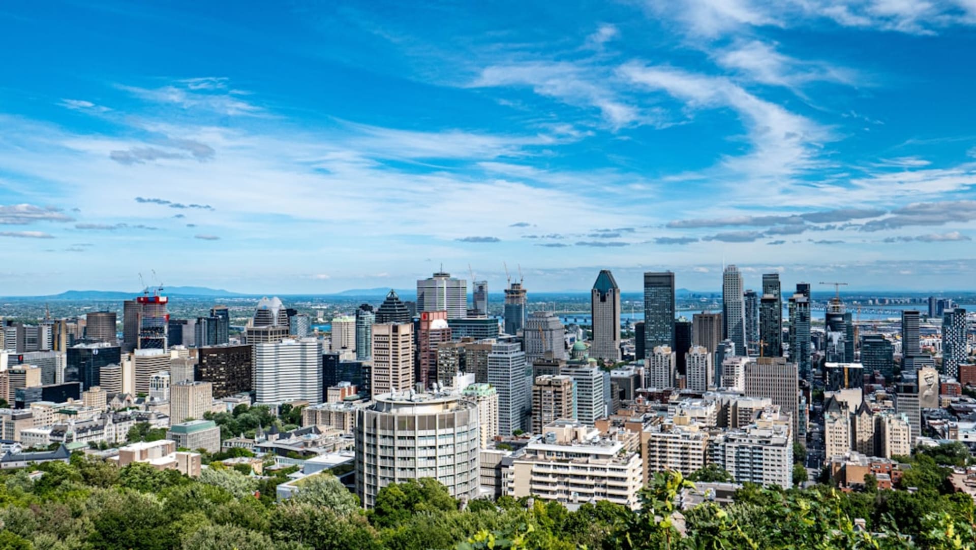 La vue sur le centre-ville de Montréal et le fleuve Saint-Laurent depuis le belvédère Kondiaronk sur le mont Royal à l'heure dorée