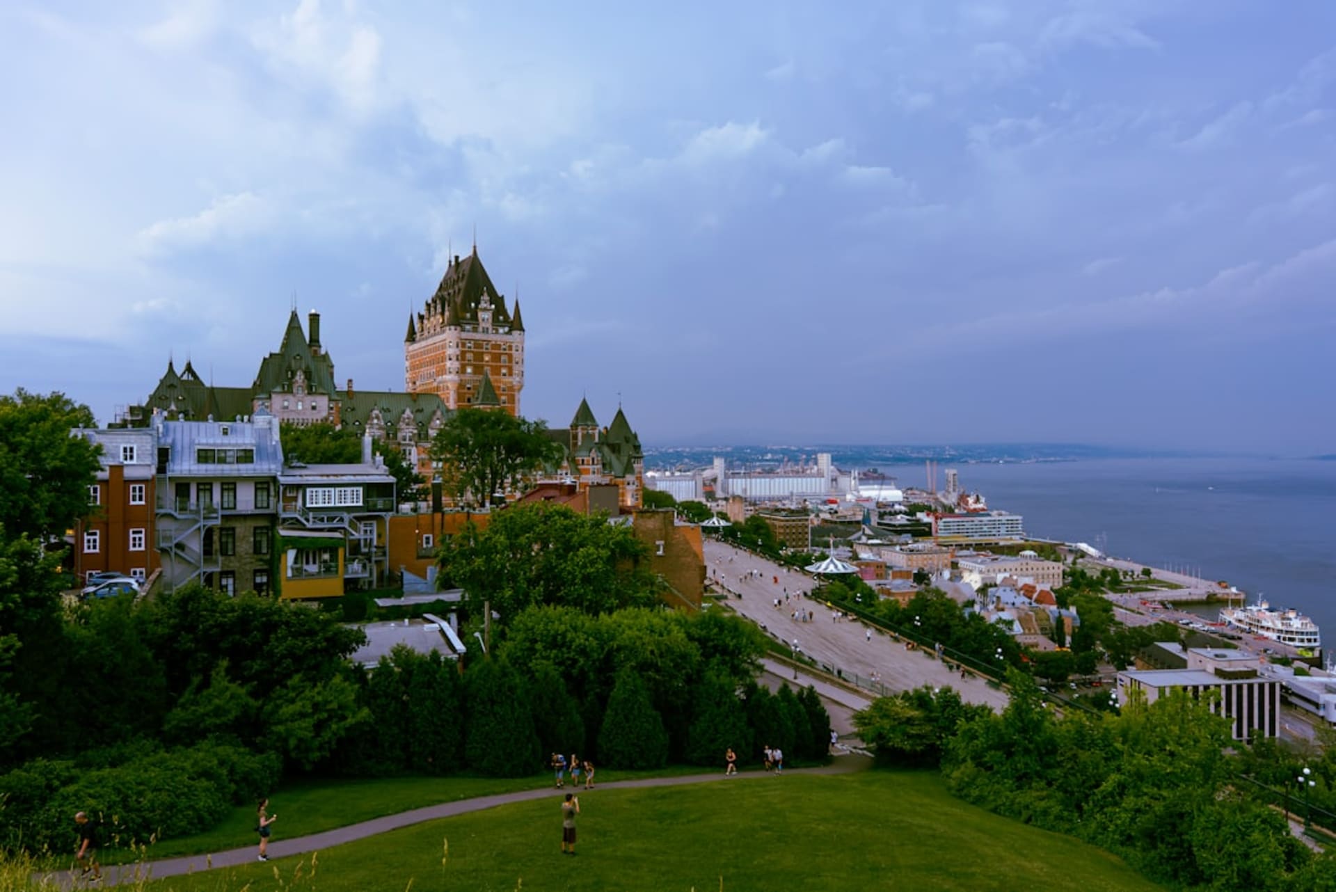 La fachada curva de piedra caliza del Museo Canadiense de Historia en Gatineau, su arquitectura glacial reflejándose en el río Ottawa al atardecer