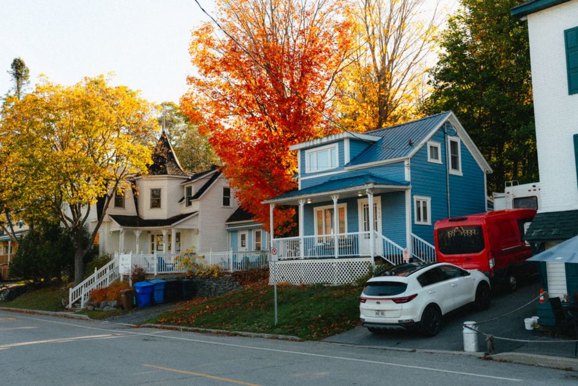 North Hatley's main street lined with historic buildings and flower baskets, the lake visible at the foot of the hill