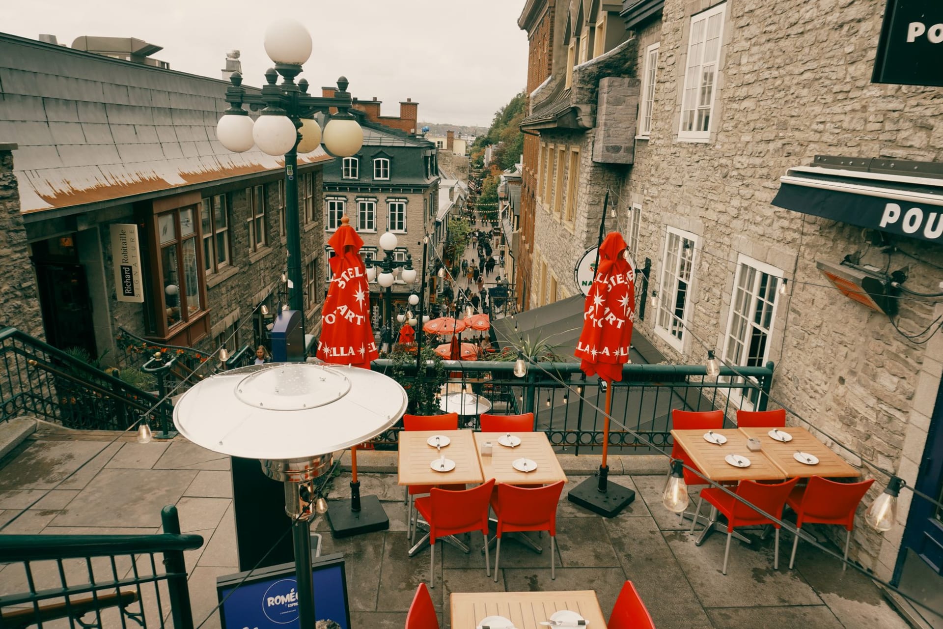 Cobblestones of Place Royale with the Fresque des Québécois mural and old stone buildings glowing in afternoon light