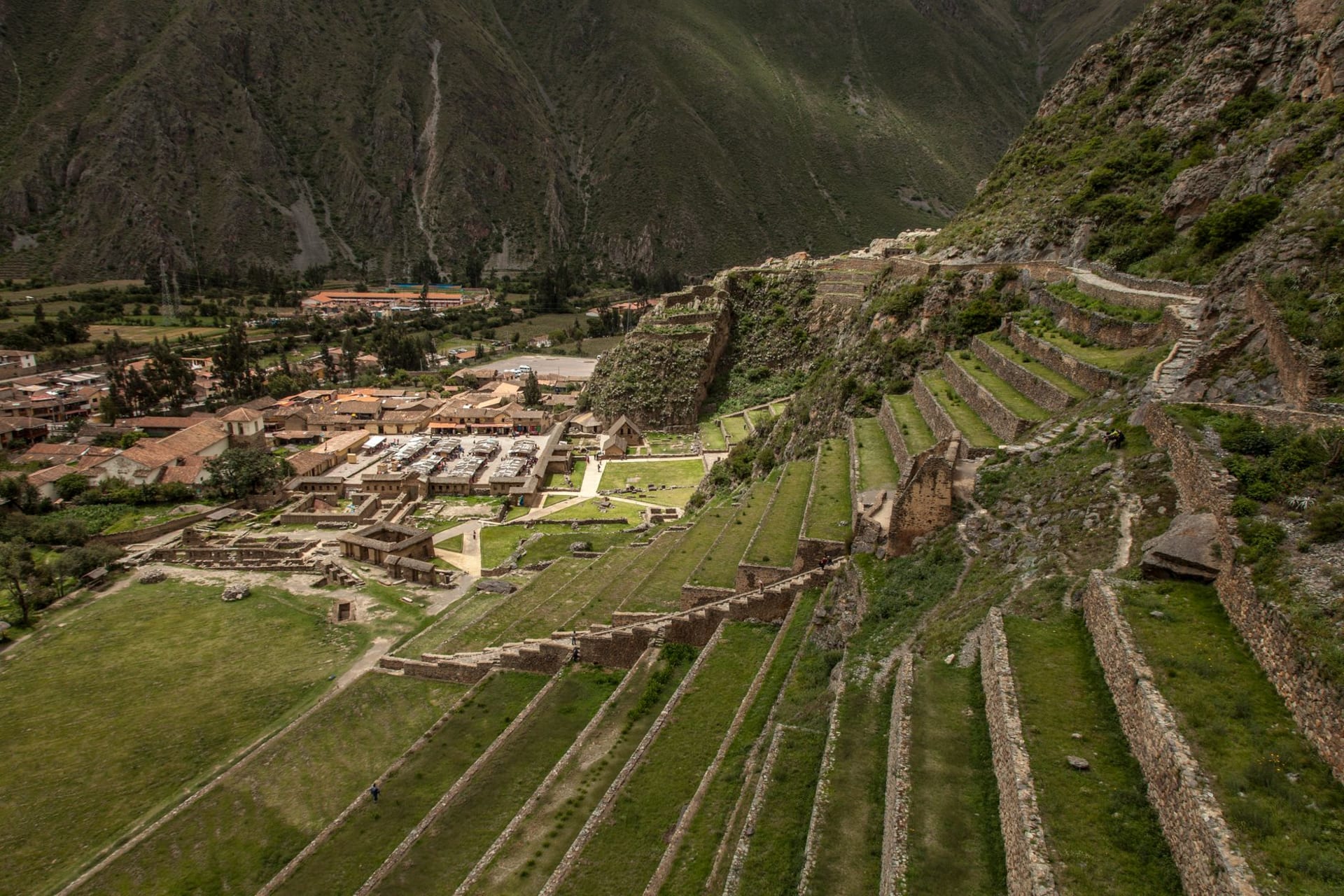 Stone Inca ruins of Huchuy Qosqo on a high green terrace overlooking the Sacred Valley and Urubamba River far below, Cusco region Peru