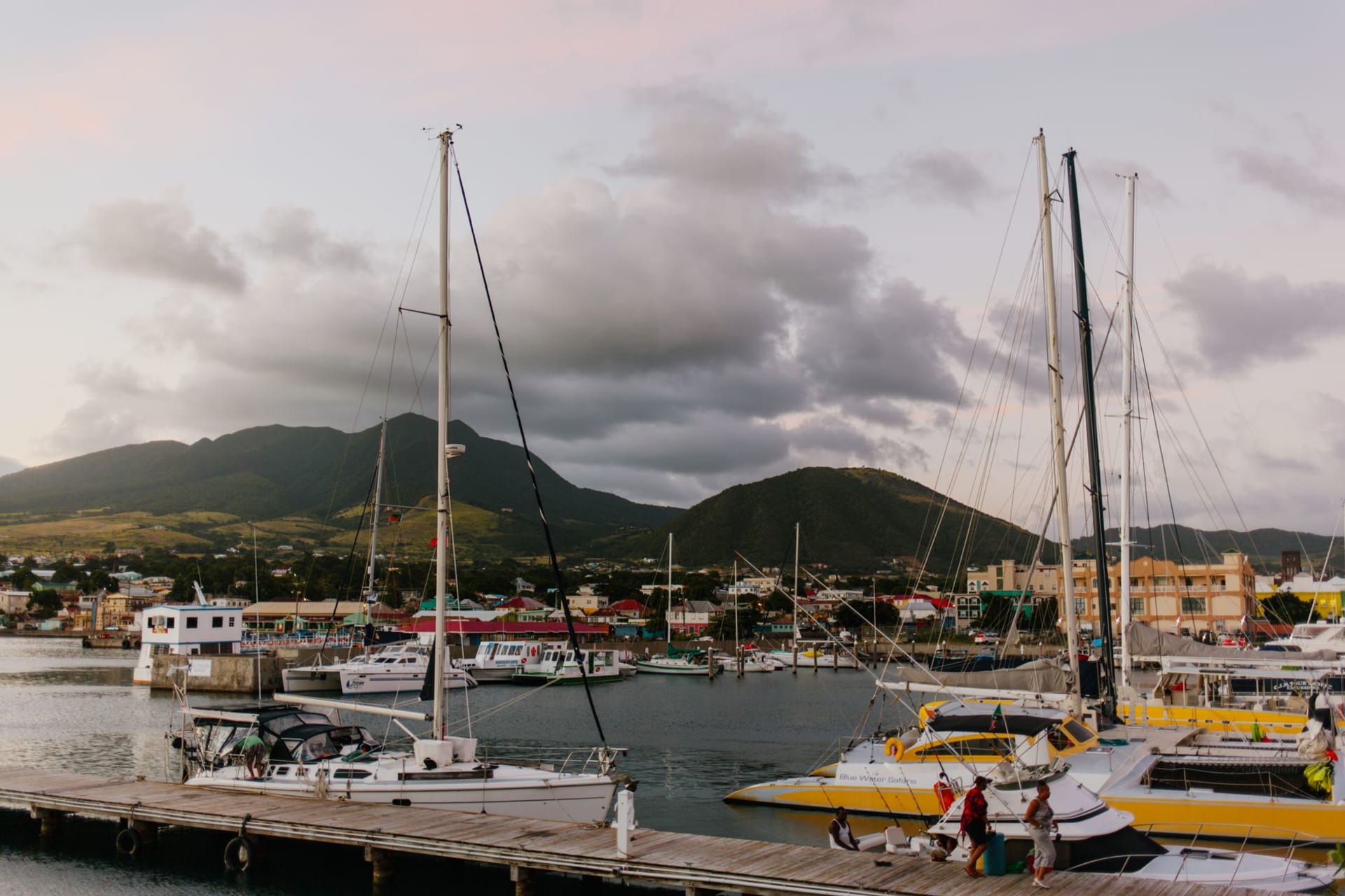 Nevis Peak volcanic summit wreathed in cloud rising above lush green slopes with the Caribbean Sea at the base