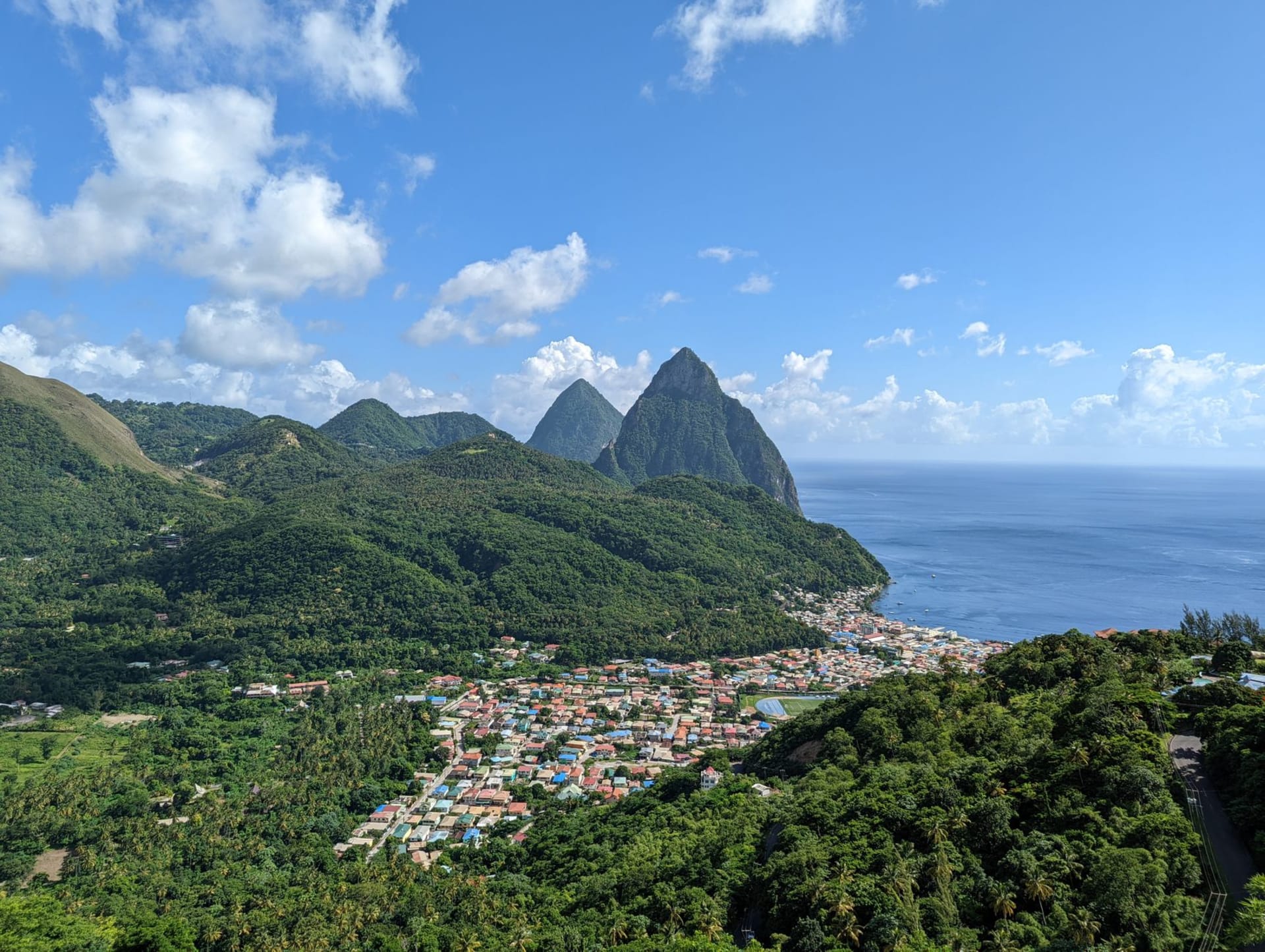 Aerial view of Soufrière town nestled between the twin Piton peaks and the Caribbean Sea, Saint Lucia