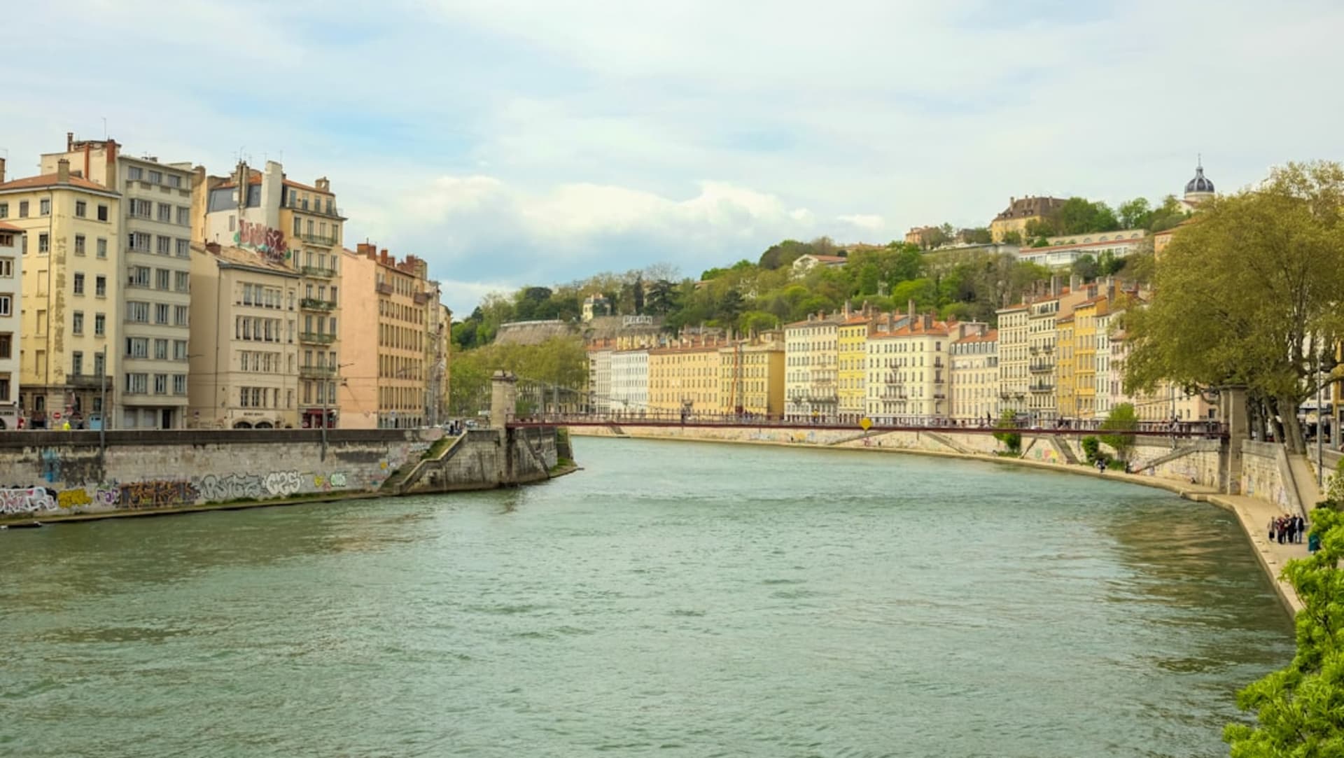 Des bateaux de pêche tirés sur le rivage de sable noir de Chateaubelair, avec des montagnes vertes s'élevant abruptement derrière le village