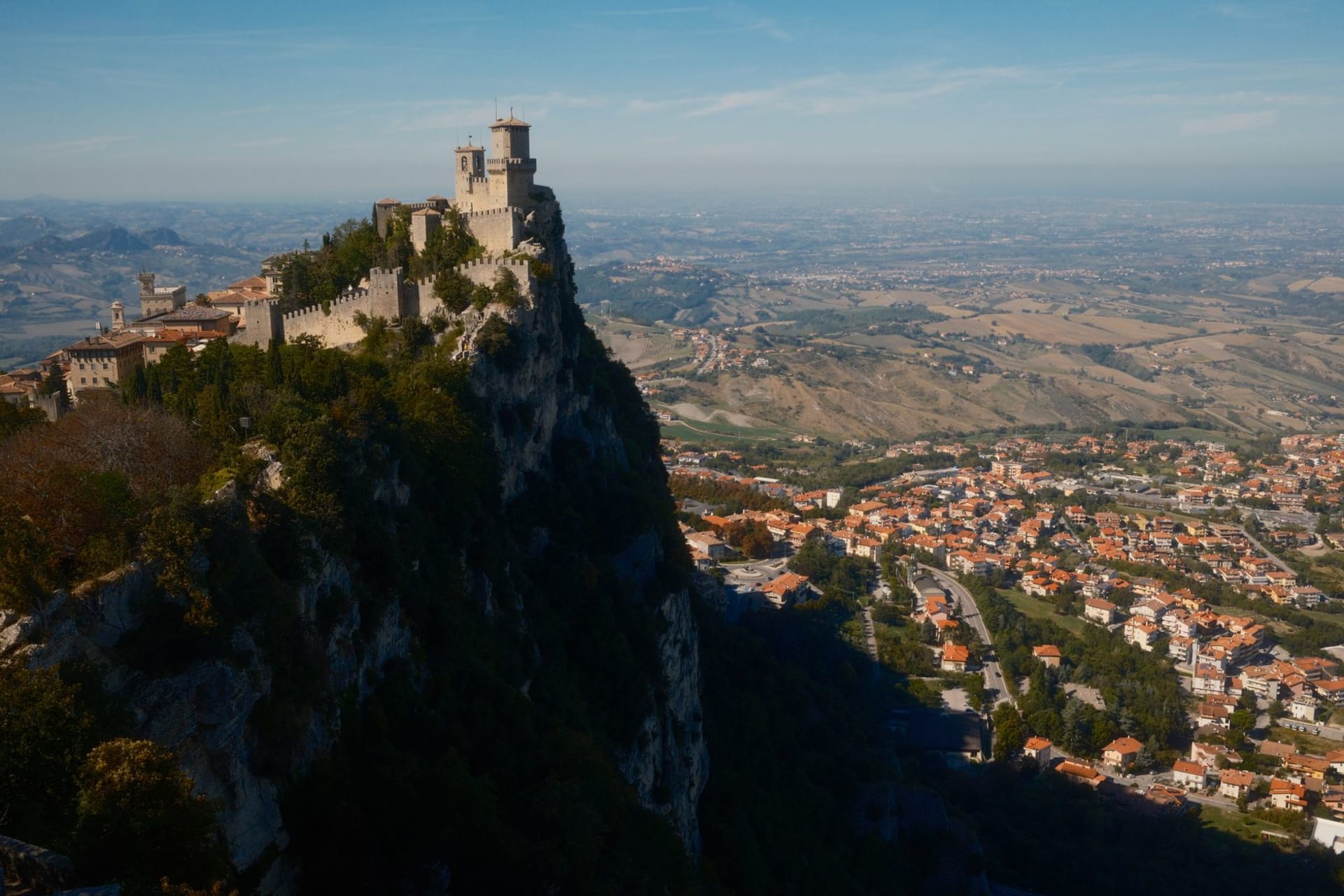 San Marino's historic fortress perched dramatically atop Mount Titano, its medieval towers rising above the surrounding Italian landscape