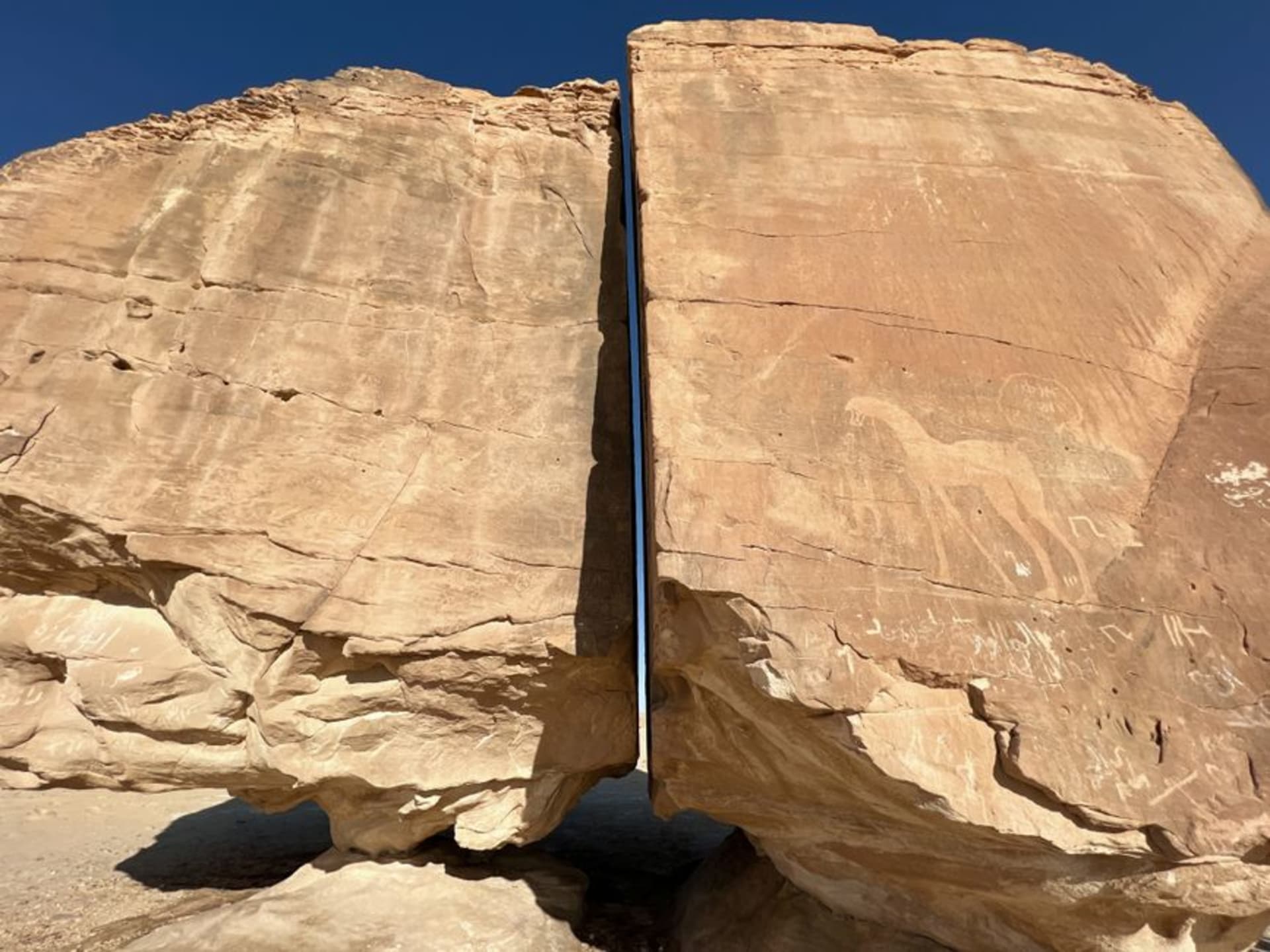 Sandstone cliffs of Jabal Umm Sinman rising from the Nefud desert at Jubbah, covered in ancient petroglyphs