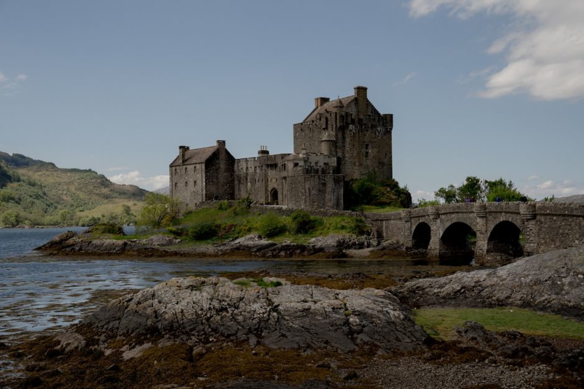 Eilean Donan Castle on its island at the confluence of Loch Duich, Loch Long, and Loch Alsh, with the stone footbridge leading to it