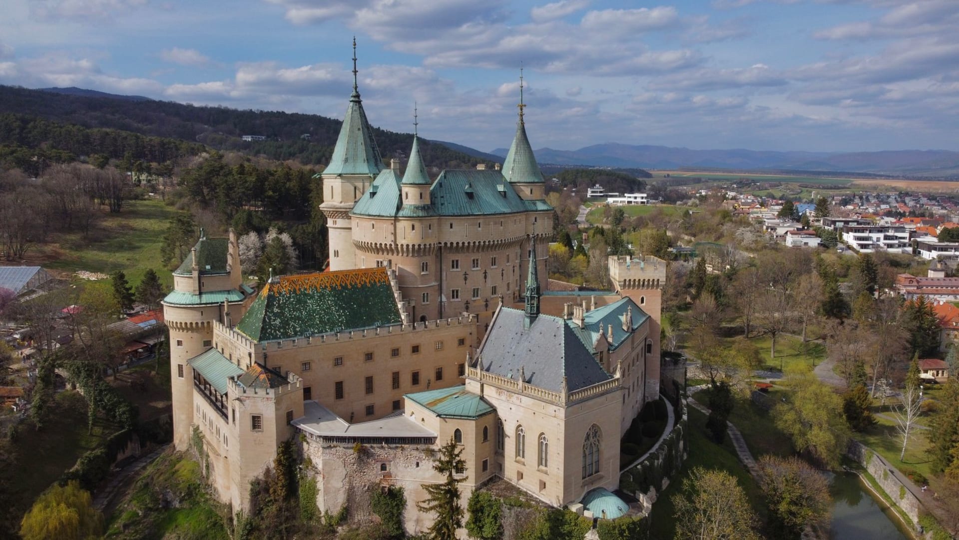 Trenčín Castle's long battlemented walls crowning the sandstone crag directly above the rooftops and church spires of the old town below