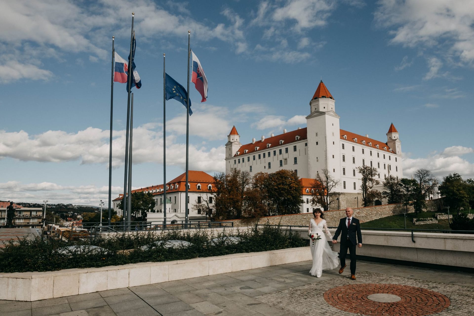 The vast pale ruins of Spiš Castle crowning a green travertine hill in eastern Slovakia, with the round keep rising above broken curtain walls under a wide sky