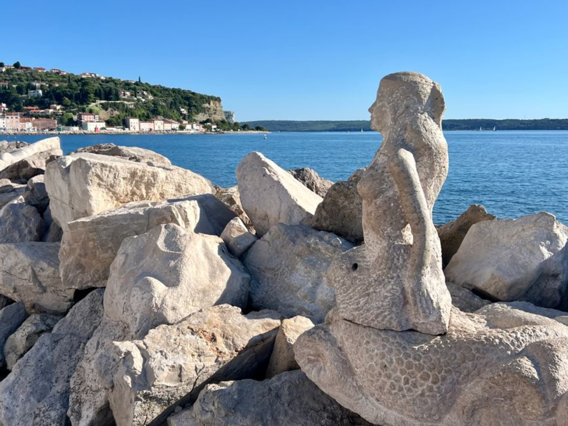 El Palacio Pretorio y la Plaza Tito en el casco antiguo de Koper, arquitectura gótica veneciana con logia y torre del reloj bajo un cielo despejado de tarde