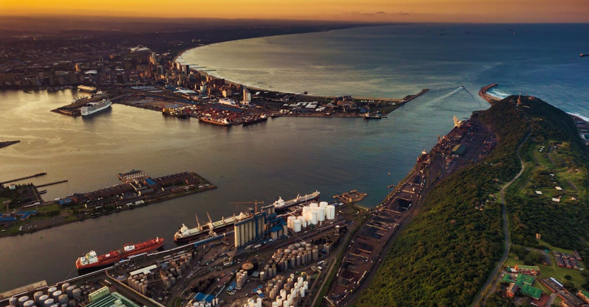 The Golden Mile beachfront promenade in Durban with surfers and the city skyline