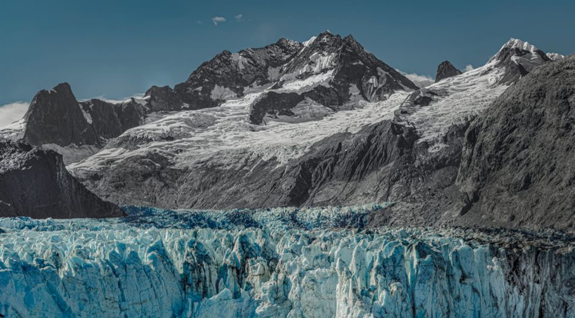 The Ventisquero Colgante hanging glacier draped over a granite cliff face above a turquoise lagoon in Queulat National Park