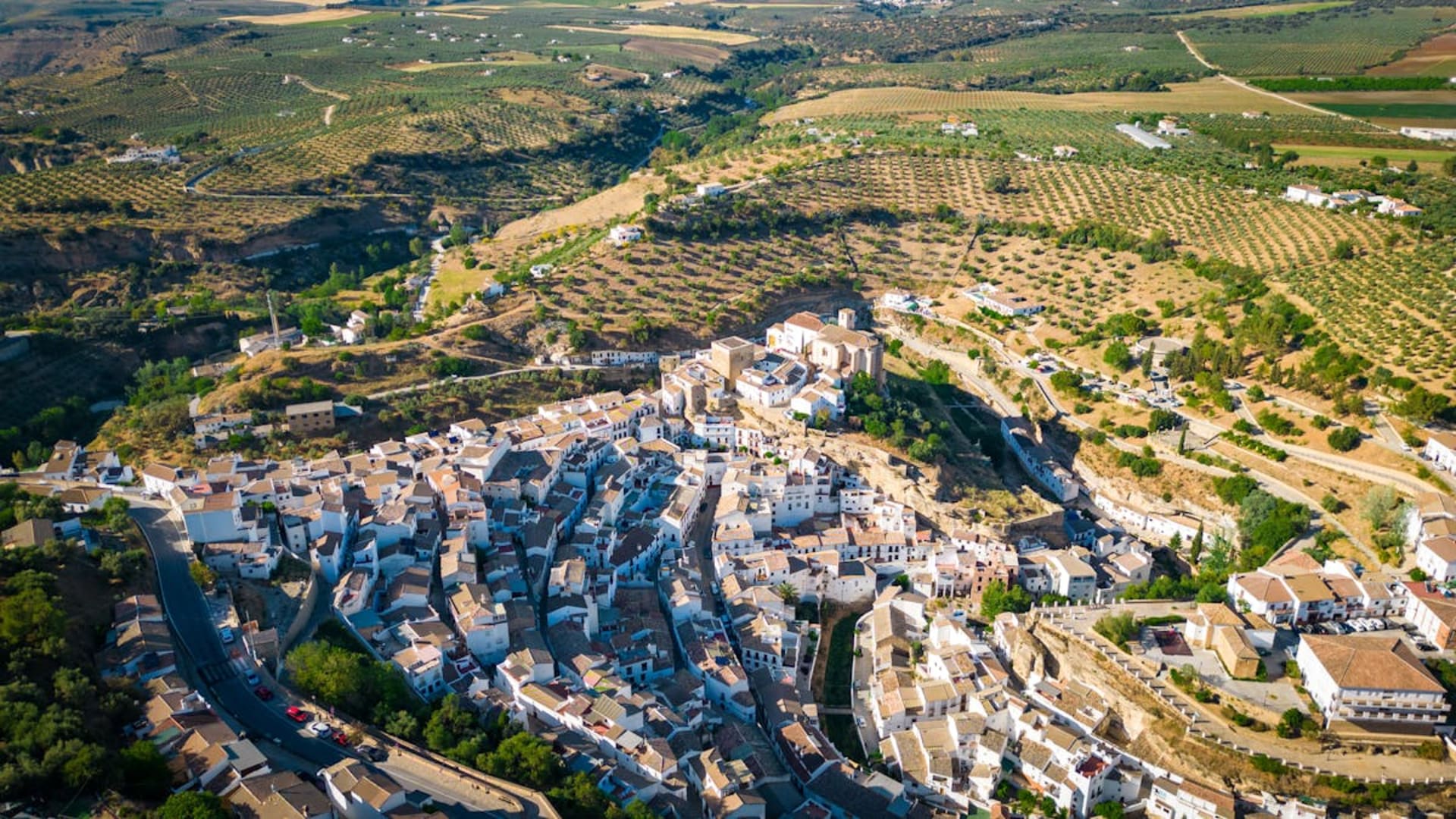 A whitewashed village clinging to a hillside under the Andalusian sun