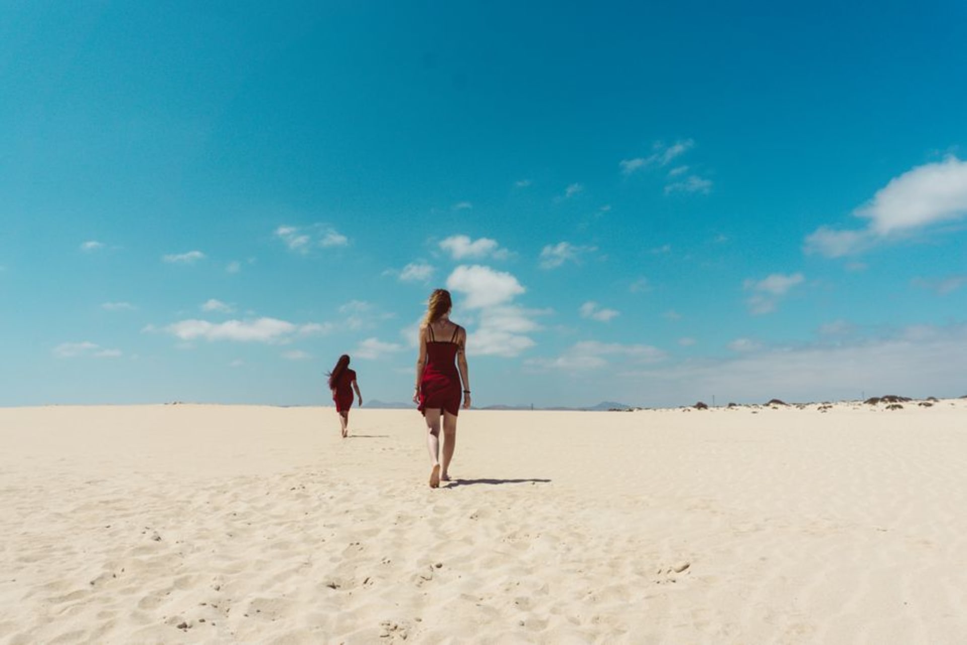 Golden dunes of Corralejo Natural Park meeting turquoise Atlantic water under a wide, cloudless sky