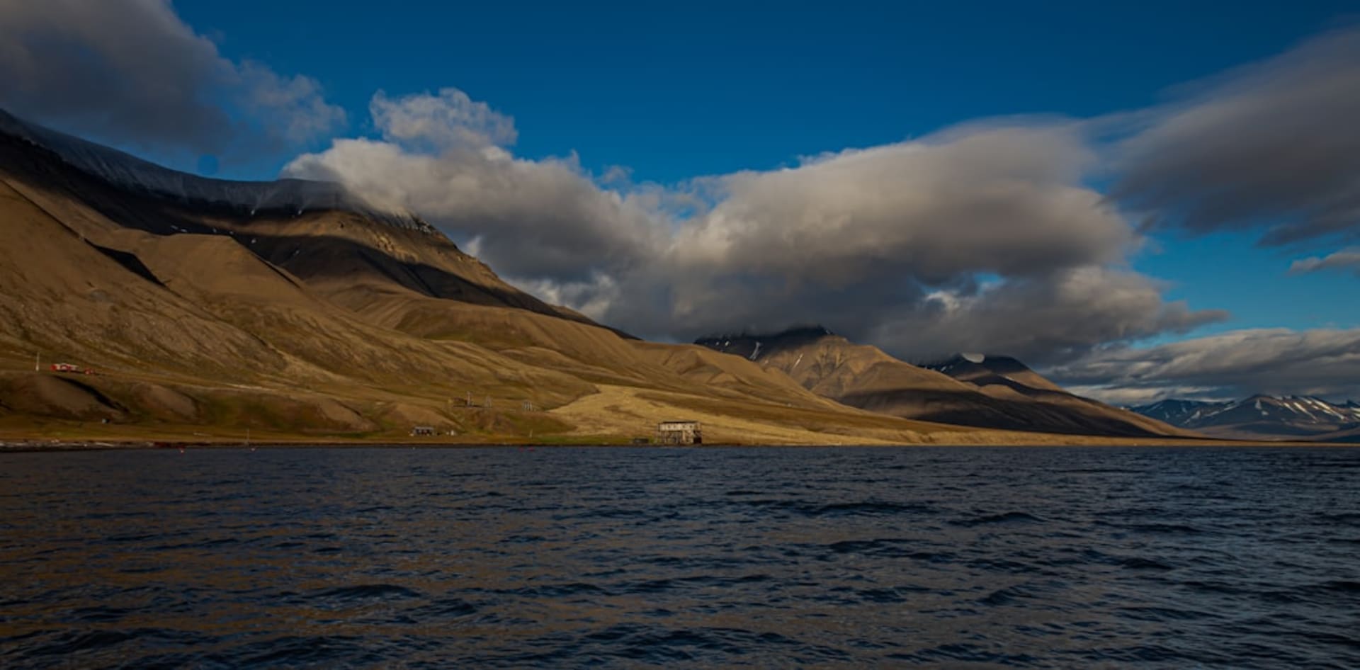 Zodiac cruising beneath the towering basalt cliffs of Alkefjellet, seabirds circling overhead