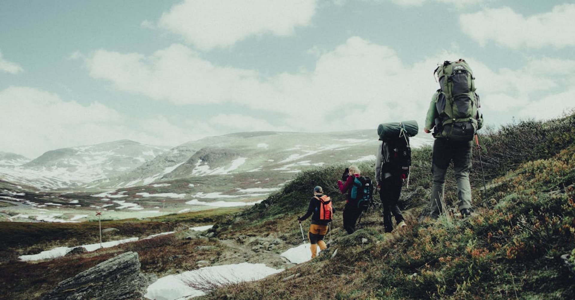 Vivid green aurora borealis arching over Abisko's frozen lake and mountain silhouette