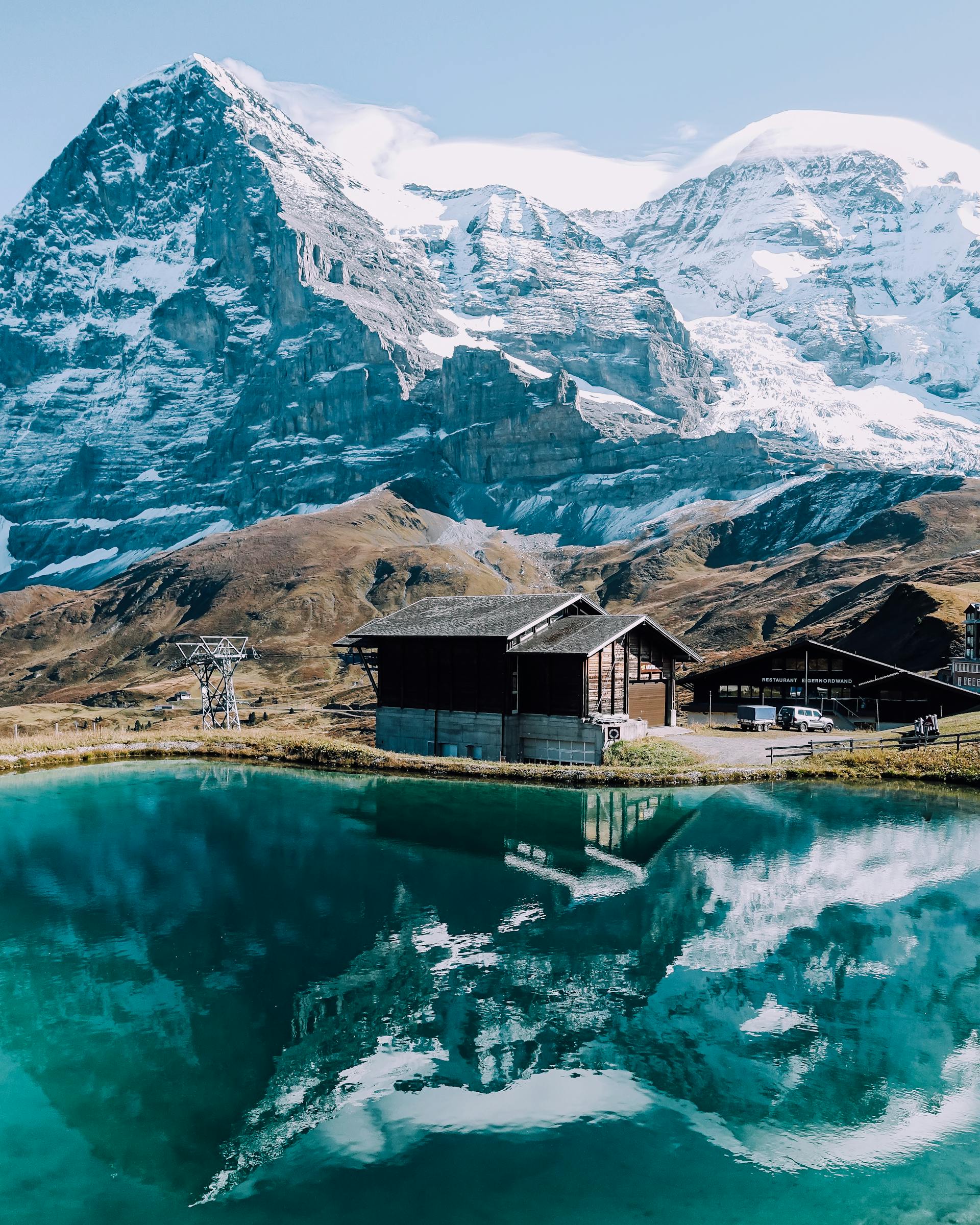 Snow-capped Alpine peaks reflected in a perfectly still mountain lake