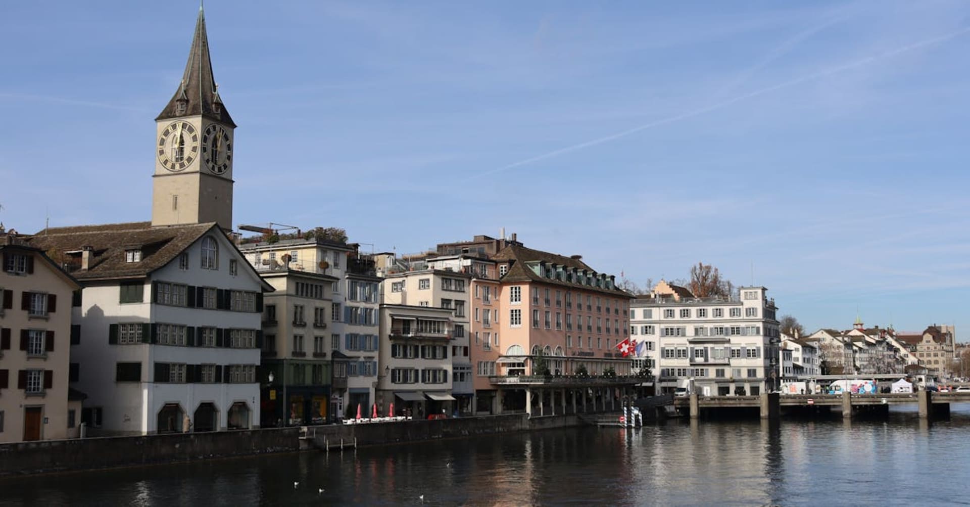 The Limmat River flowing through Zurich's Old Town with church spires reflected in the water