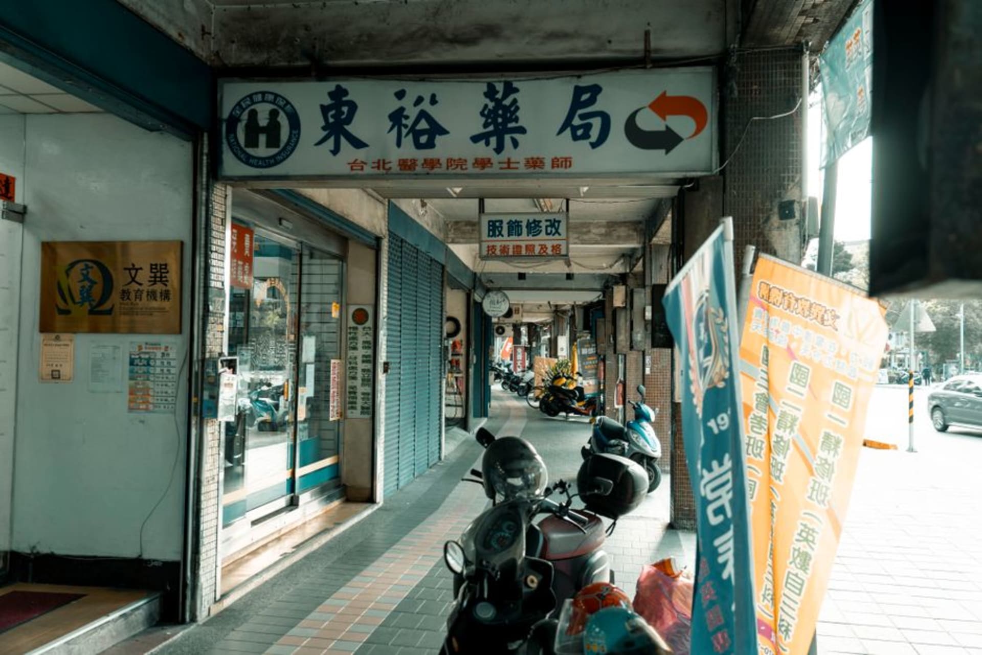 Puestos abarrotados y letreros luminosos a lo largo de la galería techada del Mercado Nocturno del Templo de Fengyuan por la noche