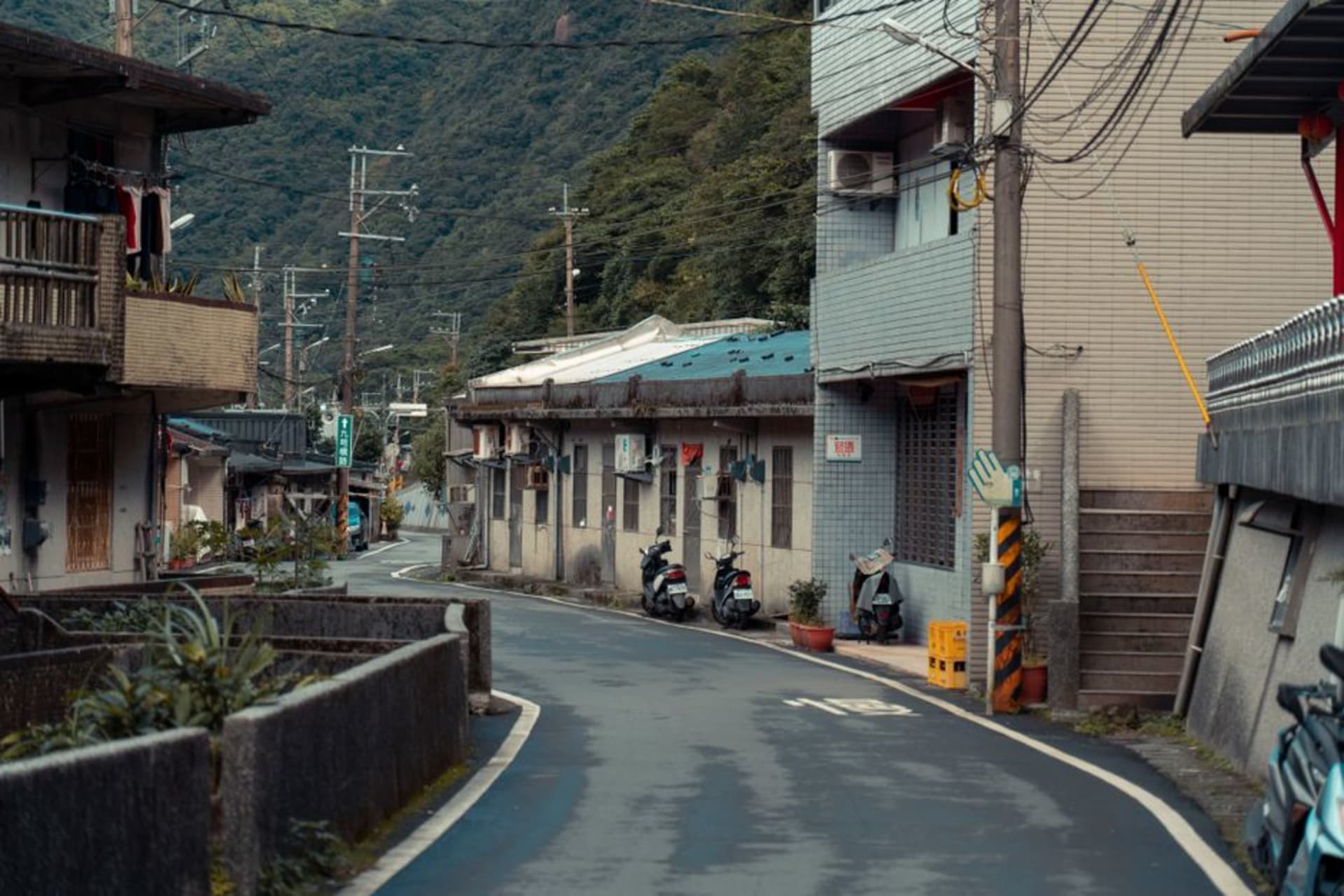 Antiguas casas de comercio de ladrillo a lo largo de una calle tranquila en Yanshui, con persianas de madera desgastadas y un farol rojo colgando sobre una puerta