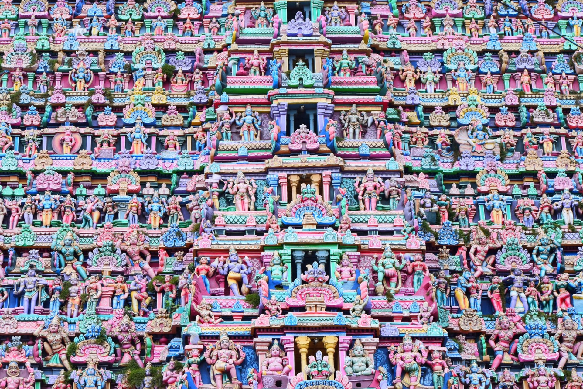 Towering colorful gopuram covered in Hindu deities rising above Kumbakonam, Tamil Nadu