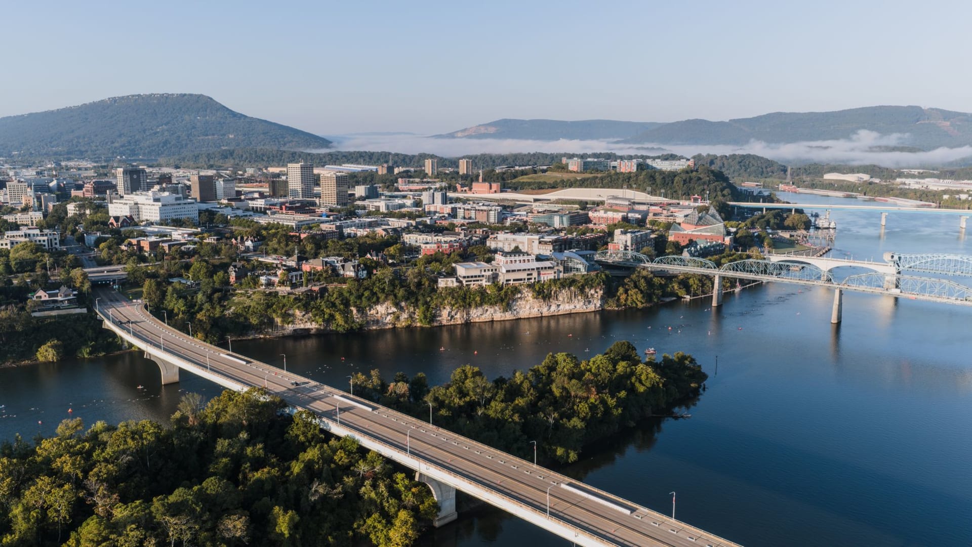 The Walnut Street pedestrian bridge over the Tennessee River at golden hour with Lookout Mountain in the background