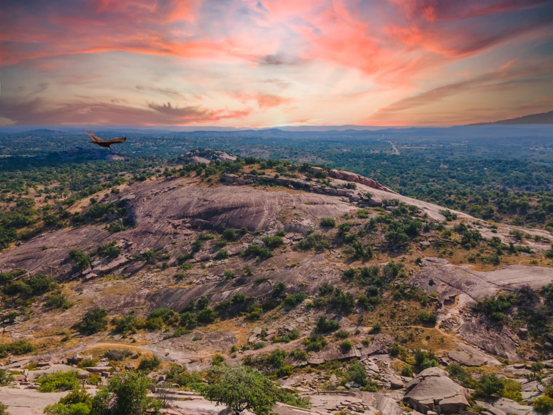 La cúpula de granito rosado de Enchanted Rock elevándose sobre el Texas Hill Country a la hora dorada