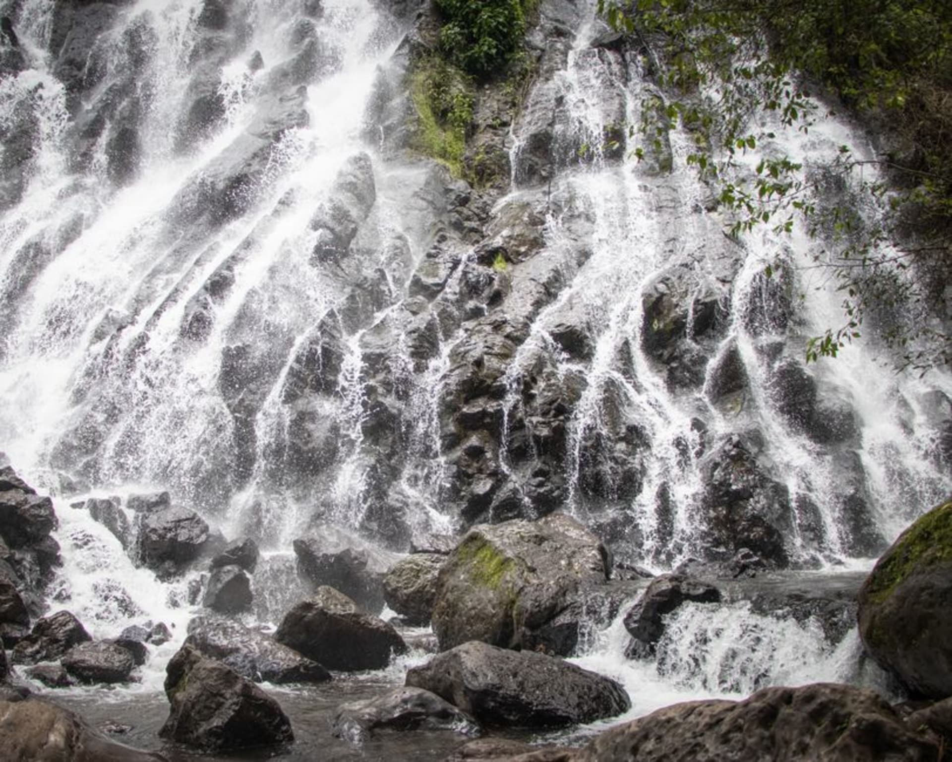 Cascade de Kpimé plunging down a steep cliff face surrounded by dense green forest