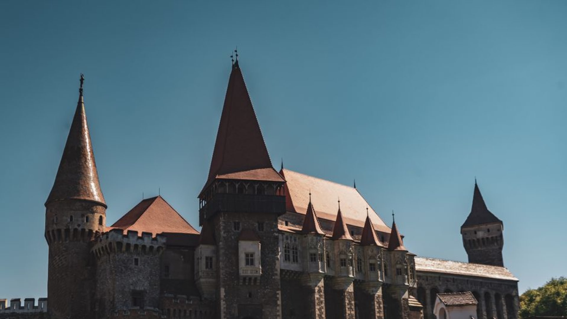 Corvin Castle's Gothic towers and stone bridge rising above Hunedoara, Romania