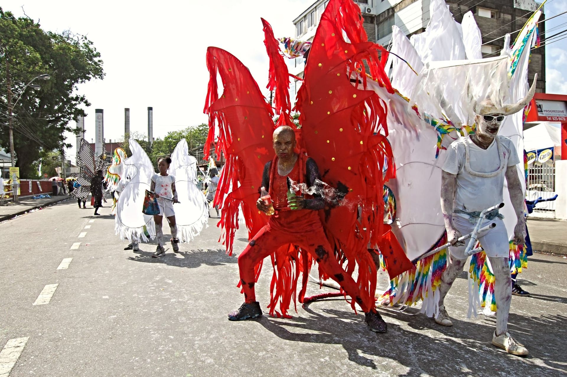 Vibrant masqueraders in elaborate beaded and feathered costumes parading through Port of Spain during Trinidad's carnival